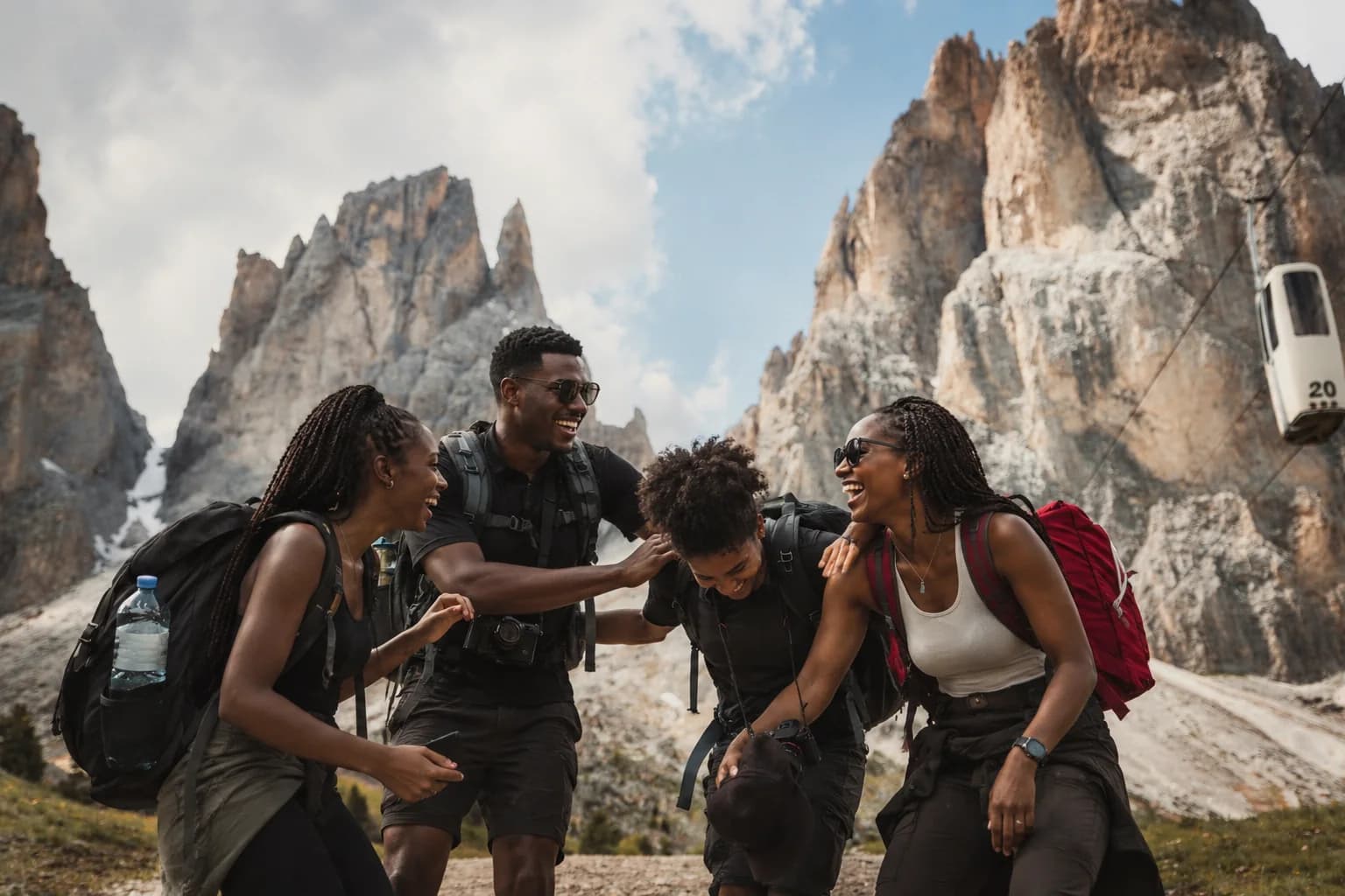 Travelers exploring mountain summit overlooking vast landscape