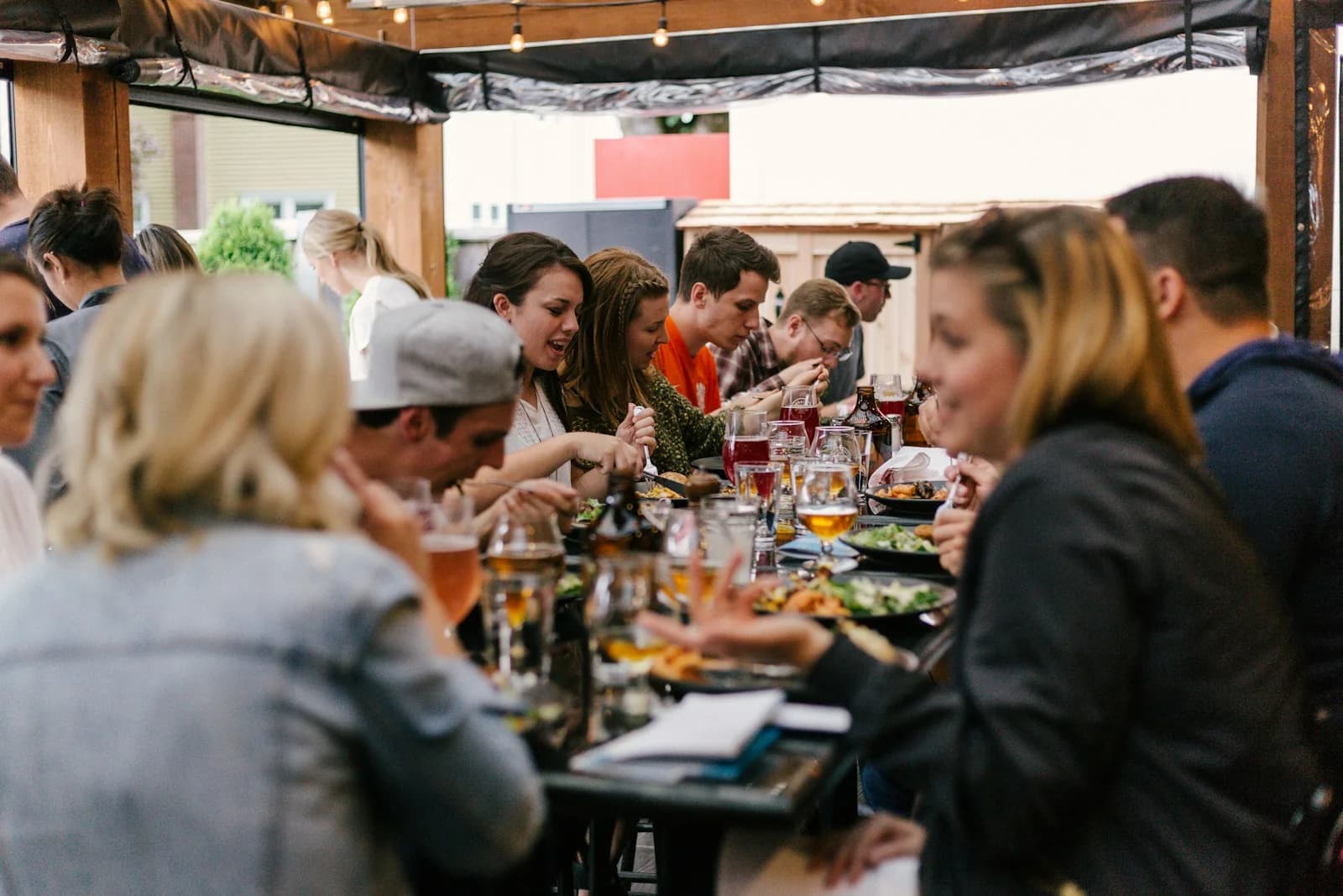 People sharing food and lively conversation at an outdoor terrace table